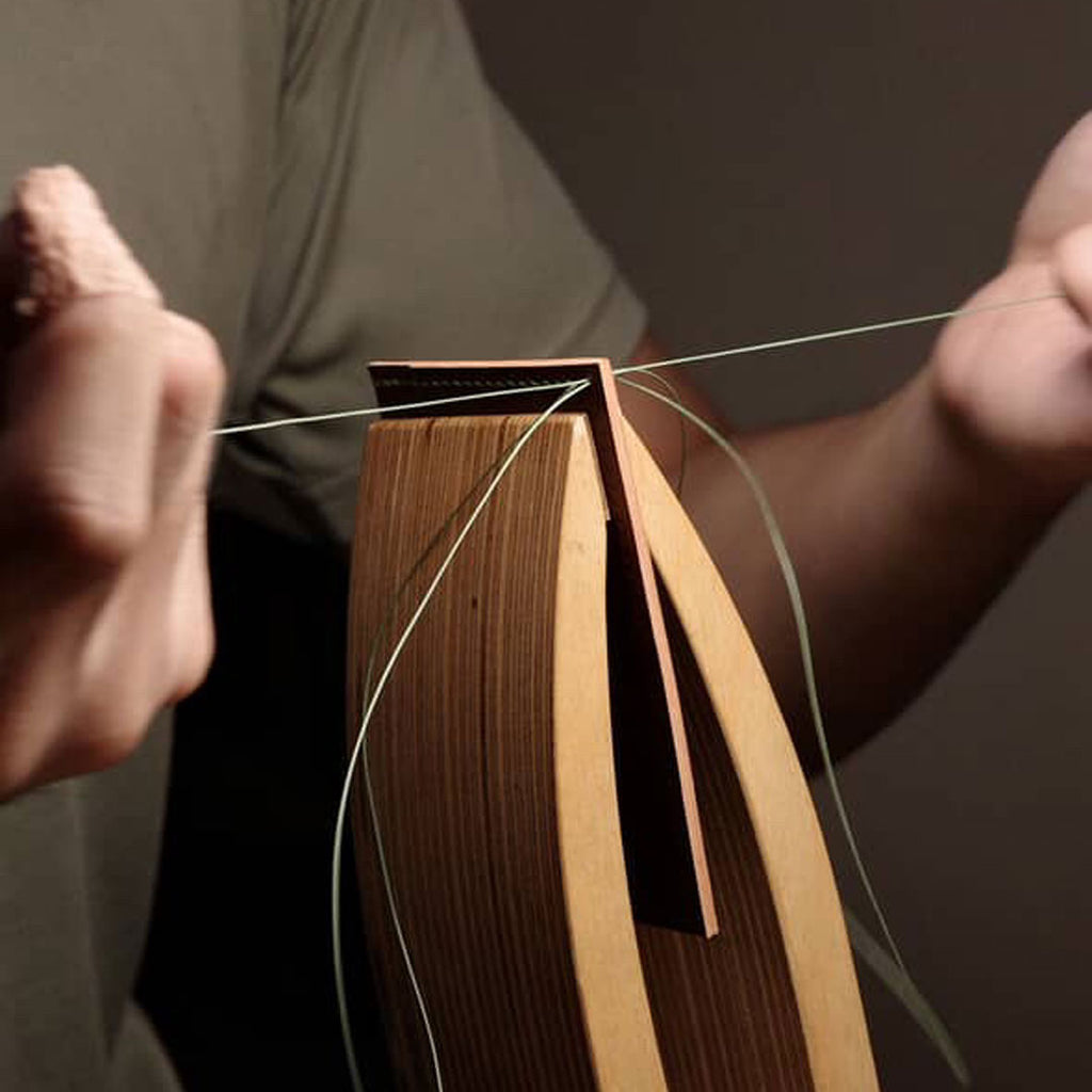 The artisan using saddle stitches to combine the leathers.