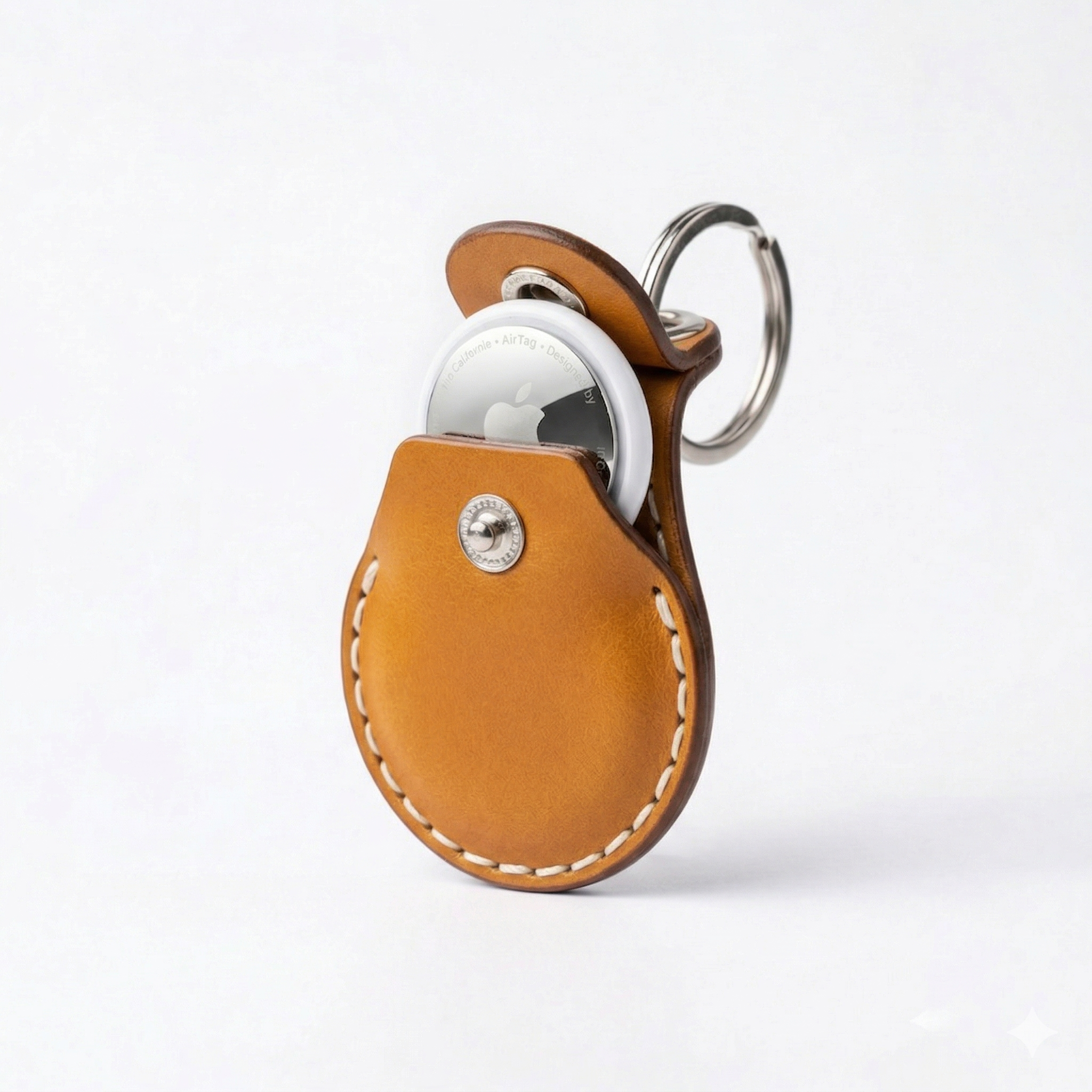 Tan leather keychain case for AirTag by VogDUO with a stainless keyring on a white background