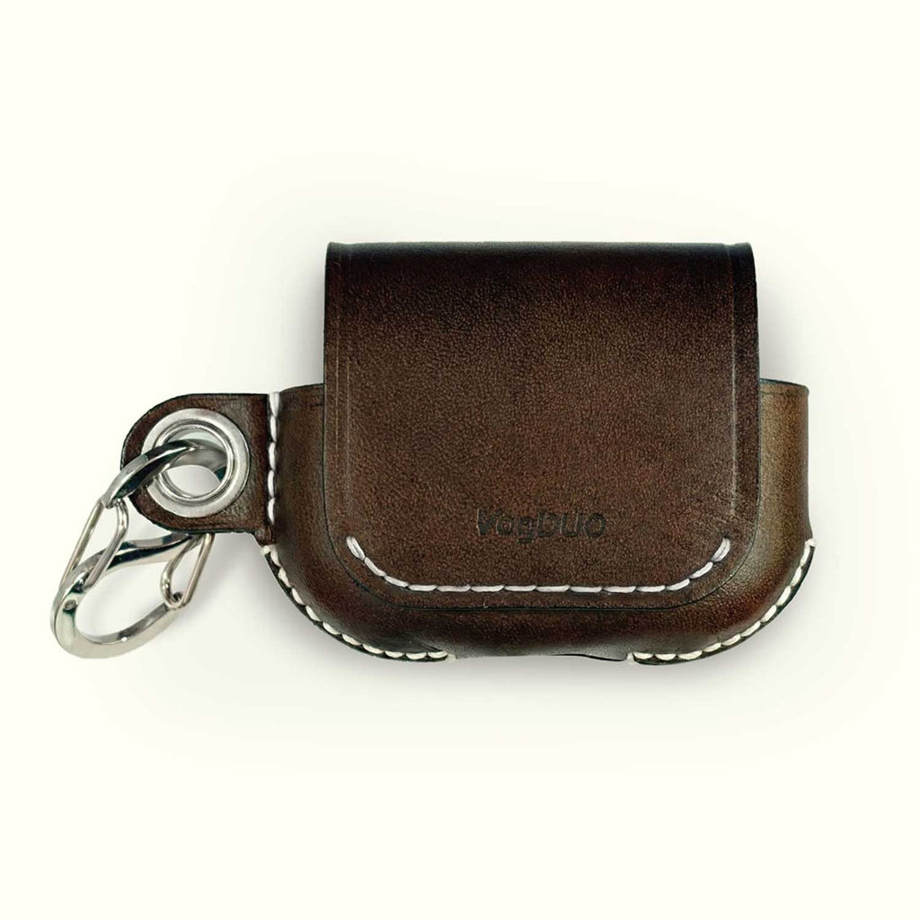 A dark brown leather AirPods case with white contrast stitching and a silver metal keychain ring, featuring the debossed brand name 'Yagbuo' on the front, set against a plain off-white background.