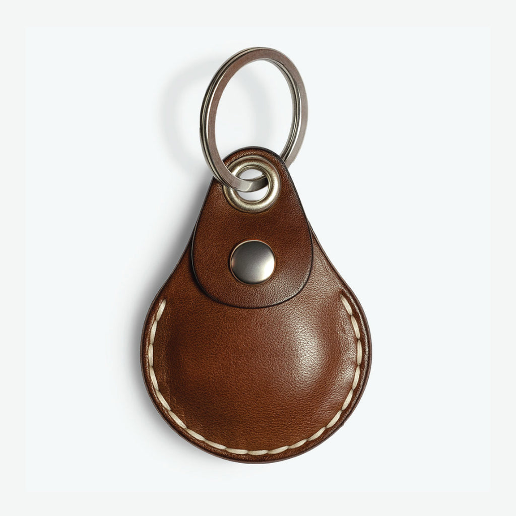 Brown AirTag leather case with keychain on a white background