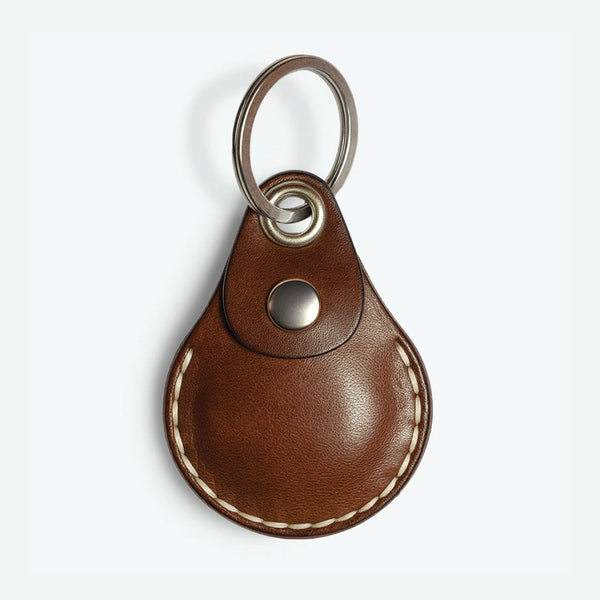 Brown AirTag leather case with keychain on a white background