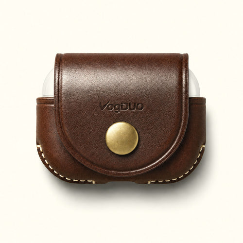 A brown leather AirPods Pro 3 case cover with a snap button closure and a brass-colored snap, featuring the VogDUO logo on the front, shown on a light cream background.