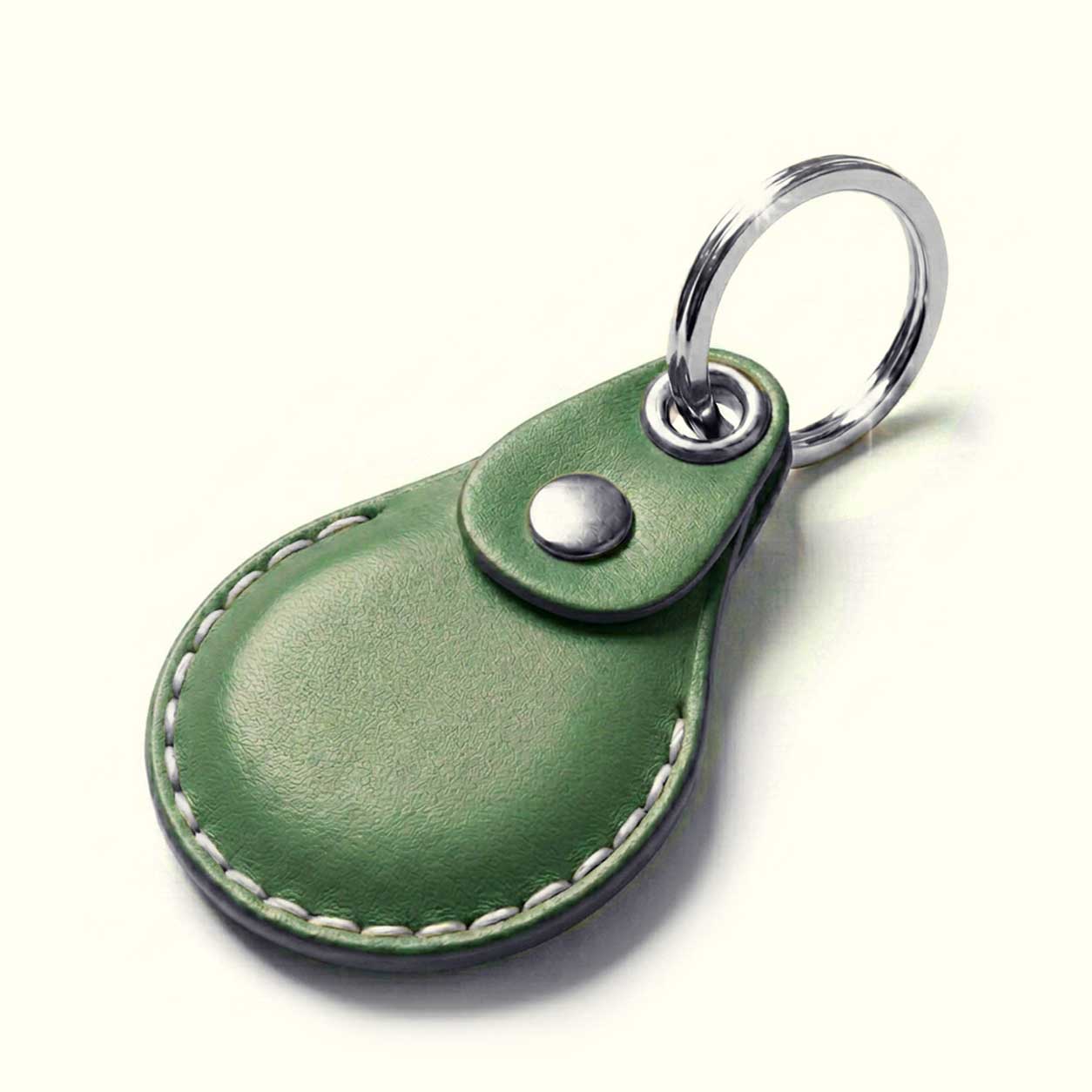 A green leather keychain case with a teardrop-shaped body for AirTag, white contrast stitching, a snap button closure, and a silver metal key ring, shown on a light cream background.