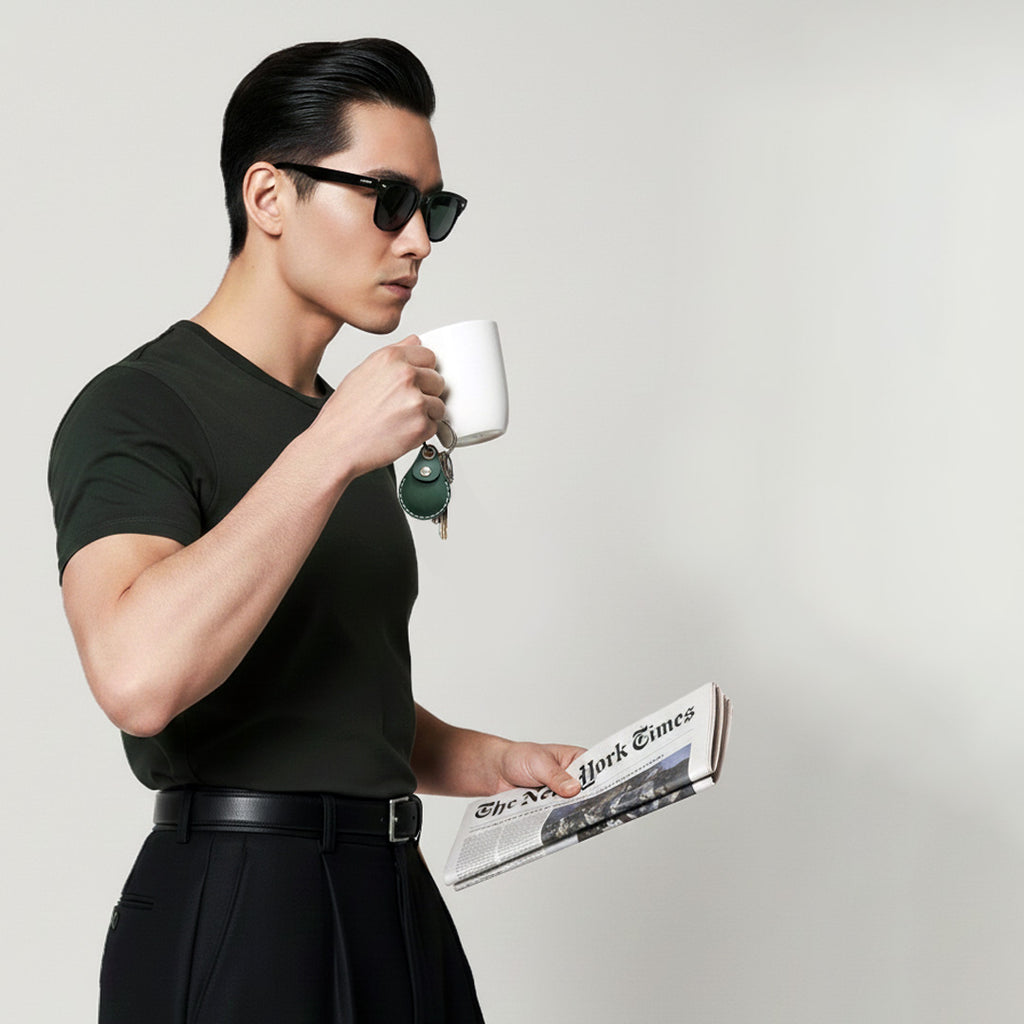A business man wearing dark green shirts, drinking coffee, carries his keychain chaining on VogDUO GreenAirTag Leather Case in style.