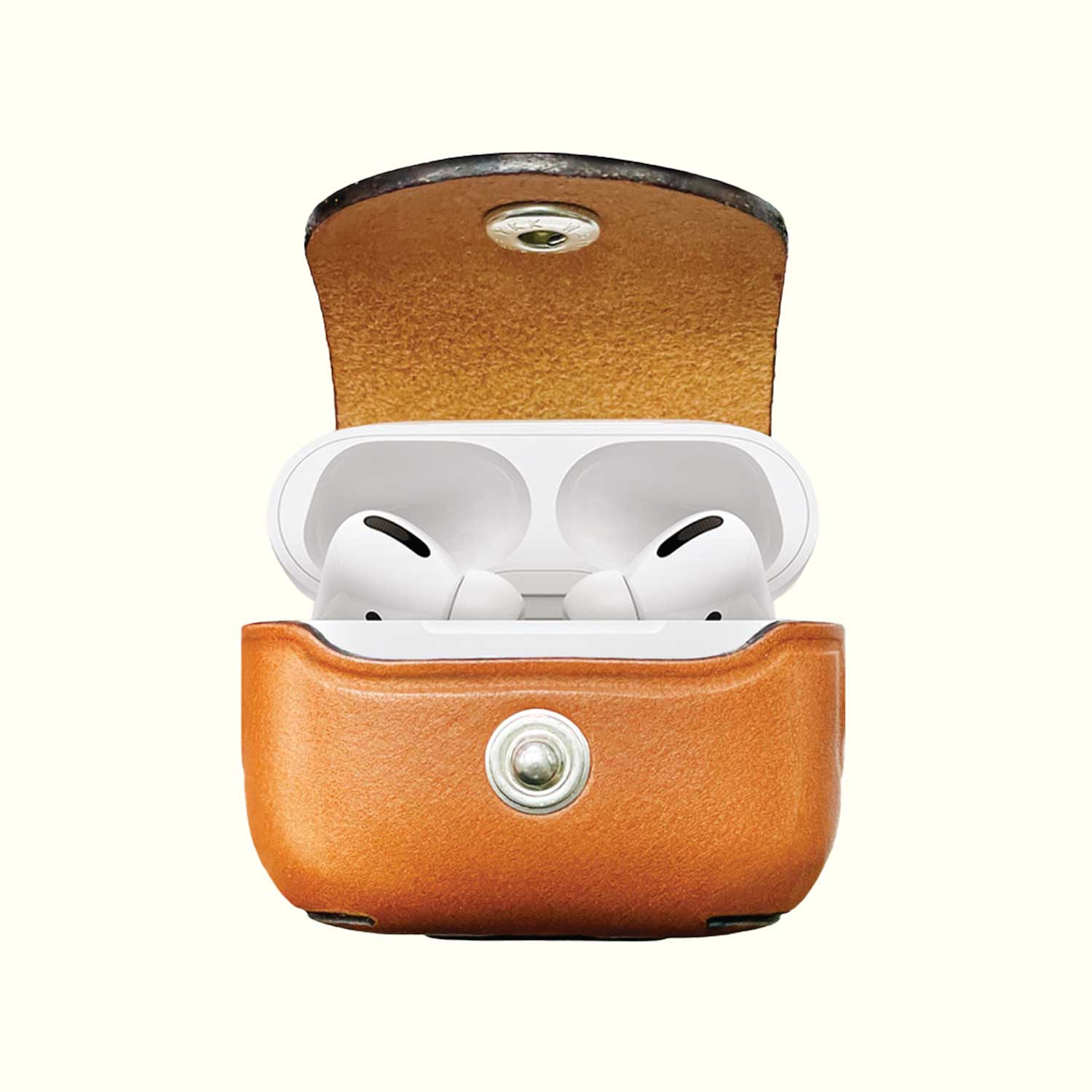 A Tan leather protective case for AirPods Pro 3, shown open with the white wireless earbuds inside, set against a solid off-white background.