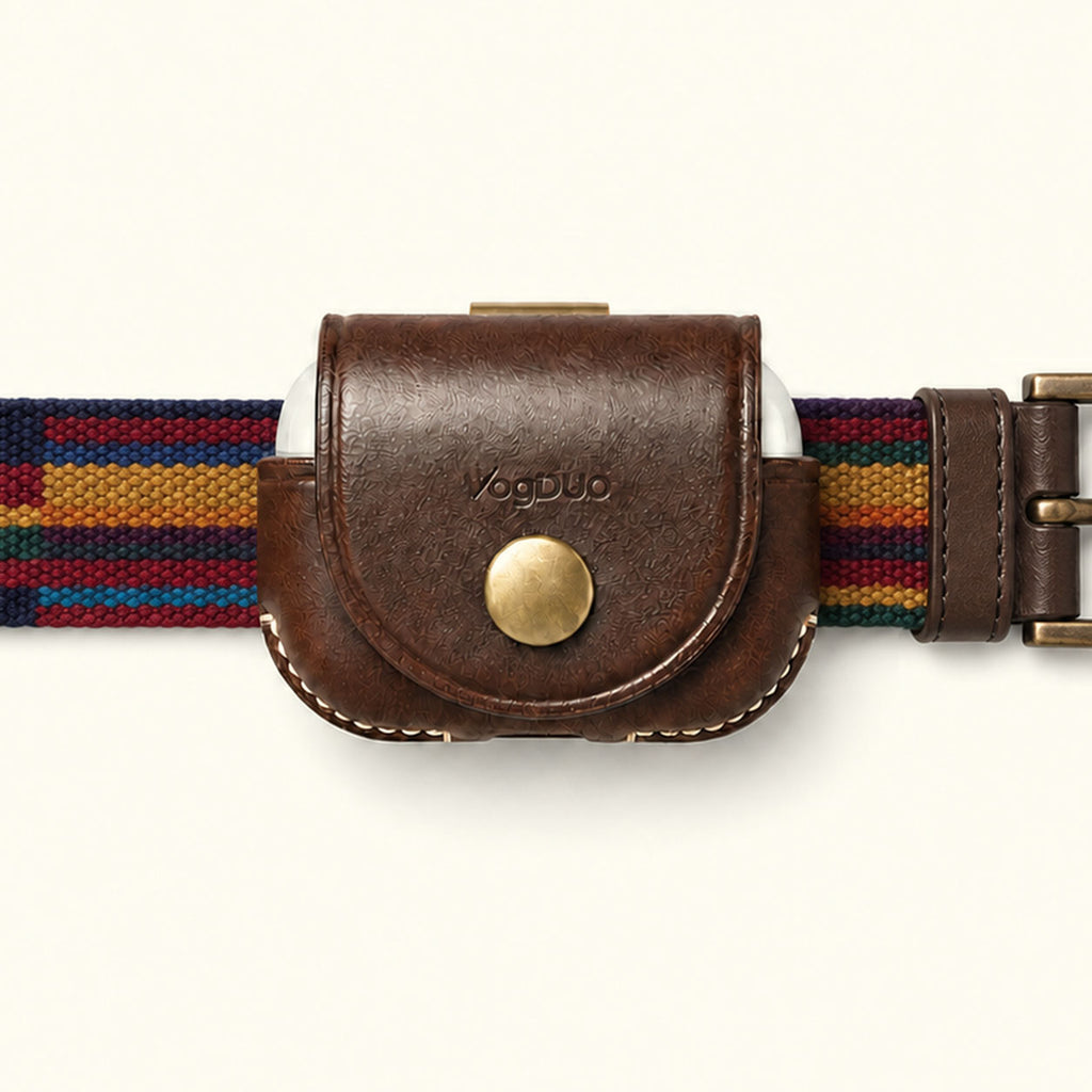 A close-up of a VagDUO belt-clip Case for AirPods Pro 3. The center features a brown leather case with a brass snap button and debossed brand name, flanked by a woven multicolor belt strap with navy, red, yellow, and blue stripes on a light cream background.