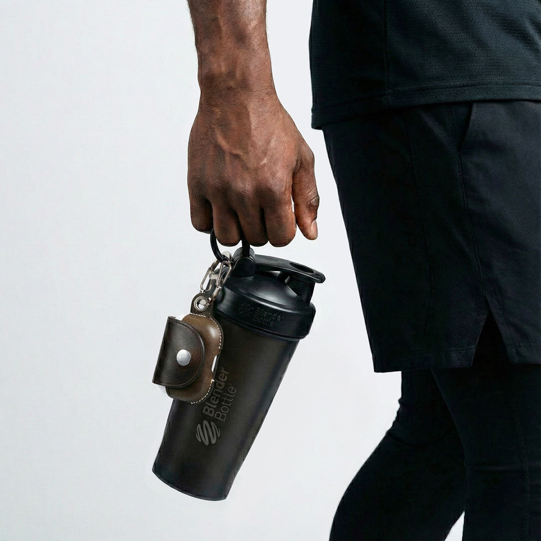 A sport man holding a black shaker bottle with VogDUO AirPods Pro 3 leather case hanging on it for super convenient and neat preparation for work out.