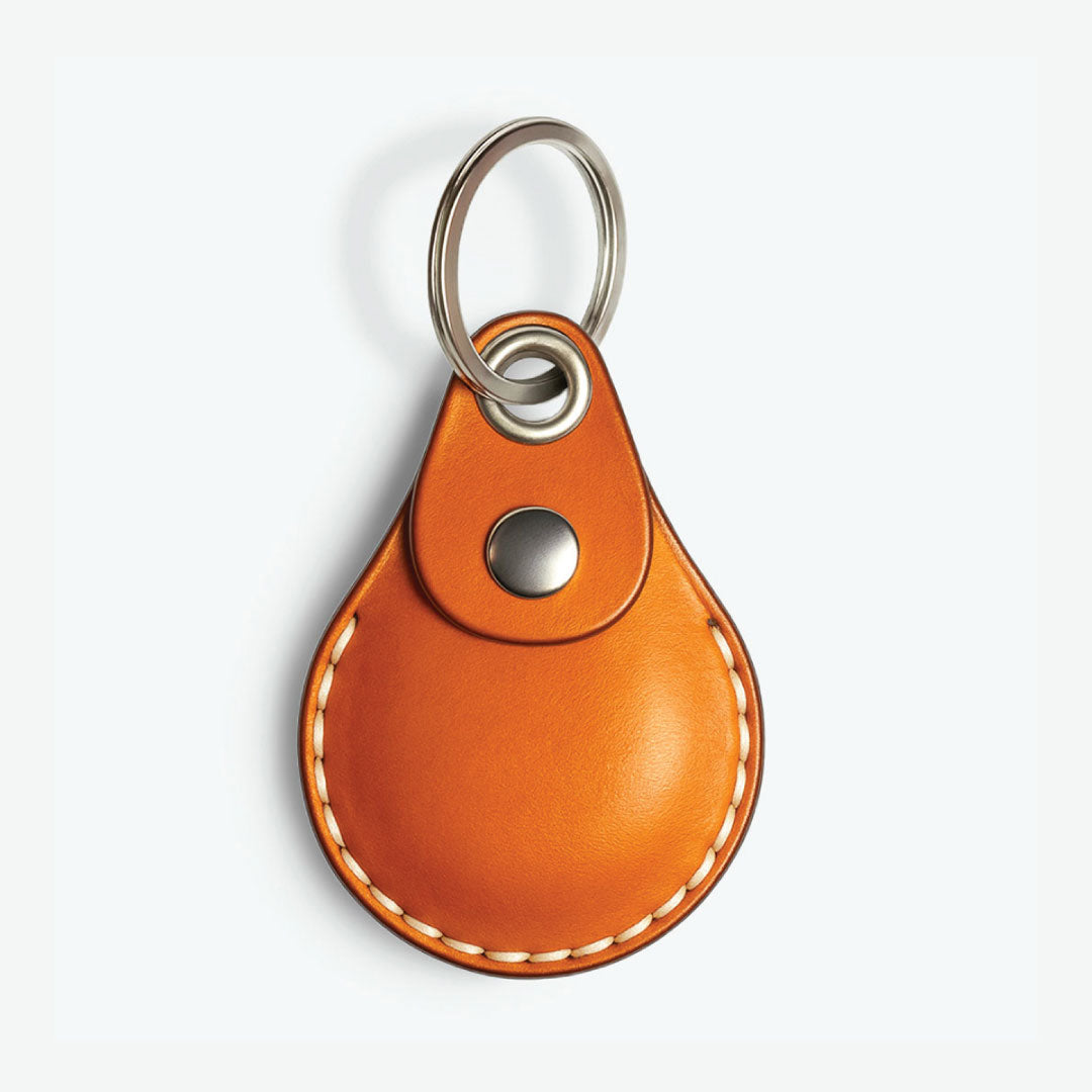 AirTag leather keychain case (Tan) with metal keyring on a white background
