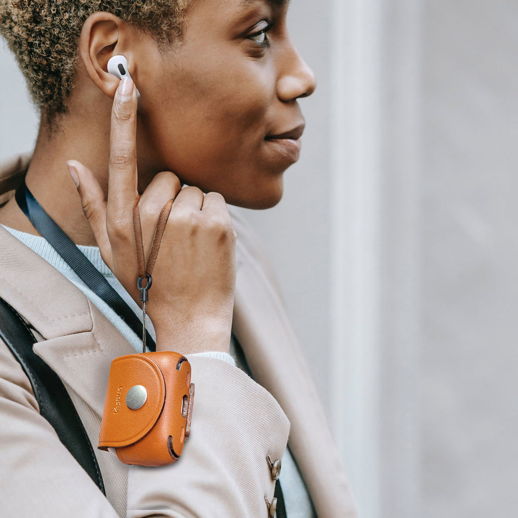 A woman listening music with AirPods Pro 3, and her hand hanging a VogDUO leather case for AirPods Pro 3 casually and smiling.