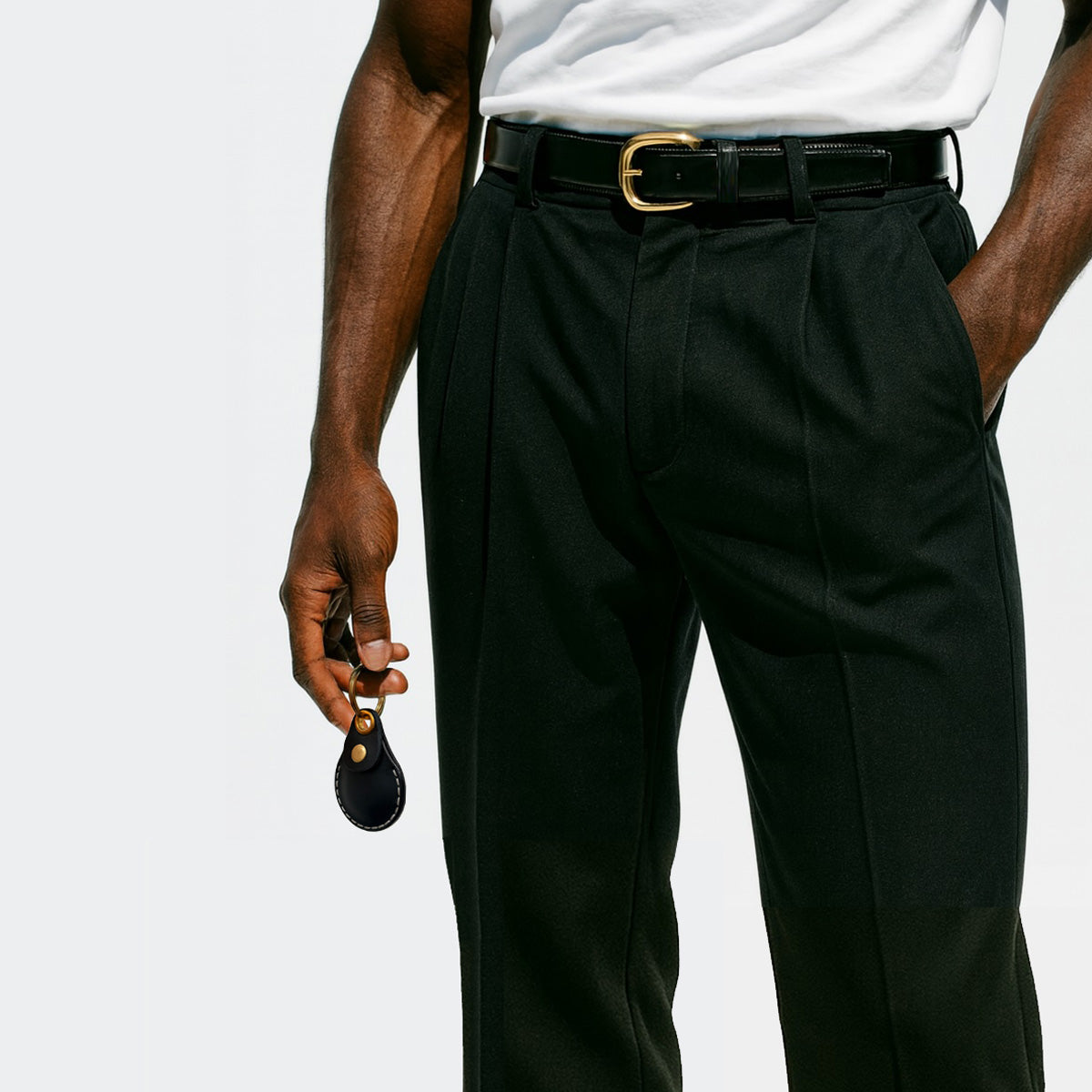 Person wearing black dress pants with a white shirt, casually carrying a VogDUO AirTag Leather case on his way home, showing stylish and confidence.